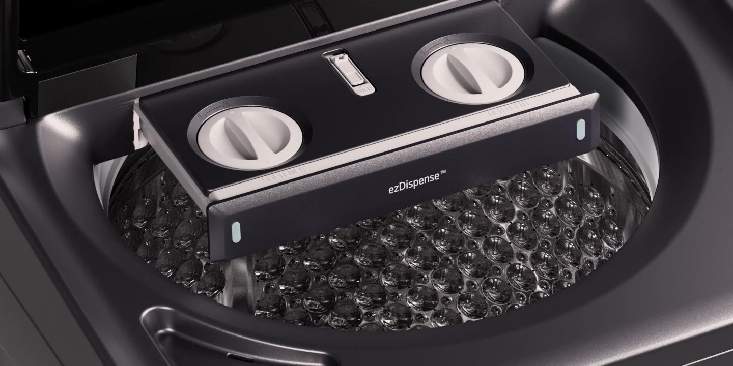 person working at a desk with an LG monitor and a laptop. The monitor displays a scene from a video or movie, while the laptop shows coding or data. The workspace is bright and organised, with plants, artwork, and a window providing natural light.